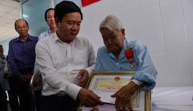 Bí thư Thành ủy TP.HCM Đinh La Thăng thăm hỏi sức khỏe mẹ Nguyễn Thị Mận sáng 5-6 - Ảnh: QUANH ĐỊNH