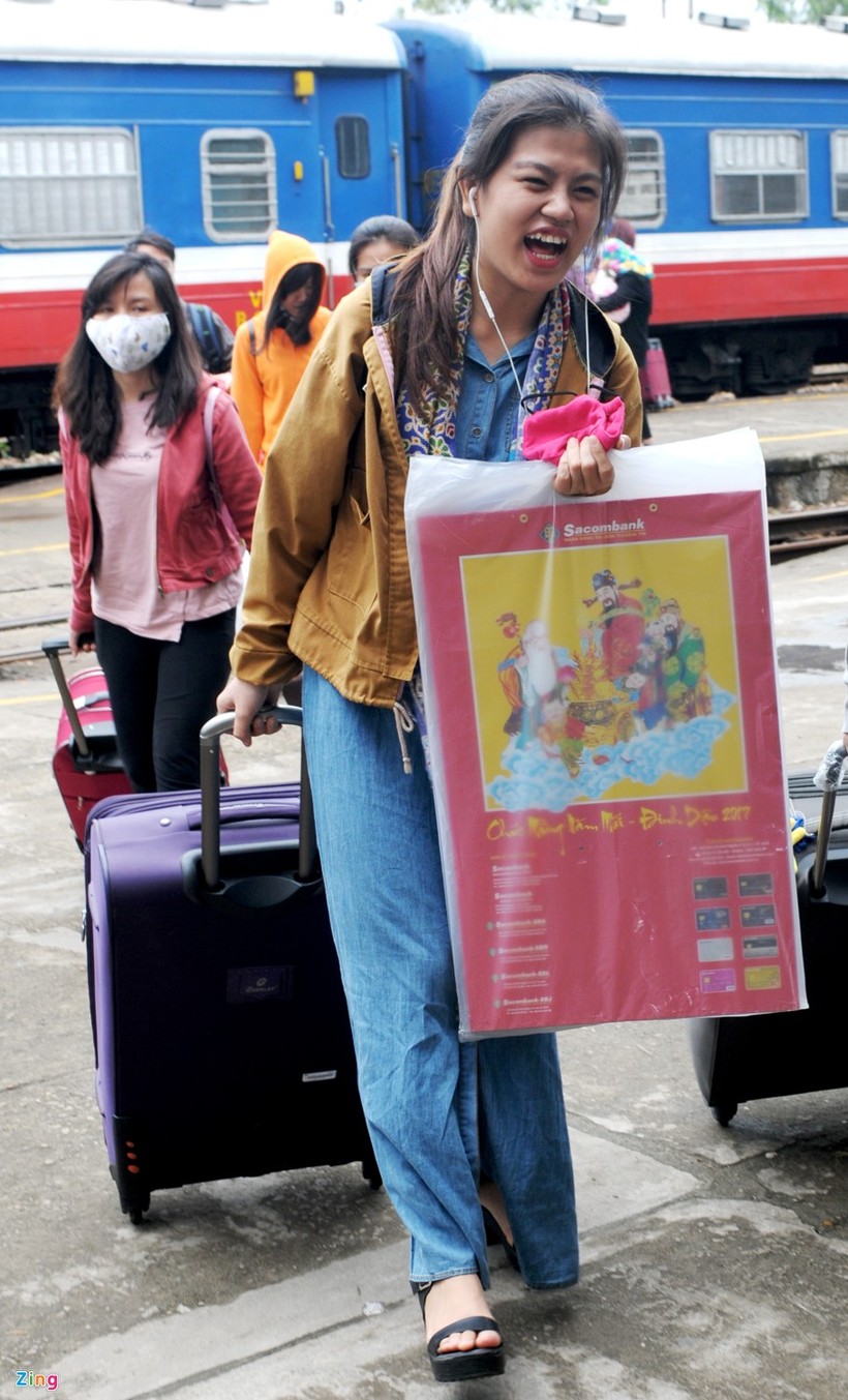 Gặp người thân từ xa ở ga Quảng Ngãi, cô gái này một tay kéo vali, tay cầm tấm lịch "Chào mừng năm mới xuân Đinh Dậu 2017" rạng ngời hạnh phúc.